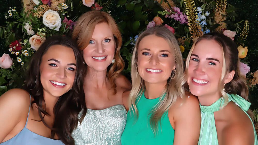 Four guests photographed in a GLAM Booth with the GLAM filter applied
